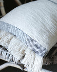 Andas cotton cushion with slate stripe on a rattan chair.