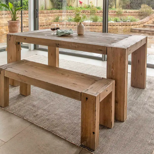 Wooden dining bench with wooden dining table in glass conservatory.