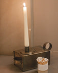 Antique Brass Candle Holder With Drawer on stone fireplace.