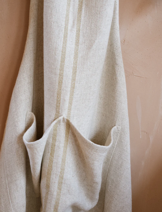 Close up of detailing on cream striped linen apron.