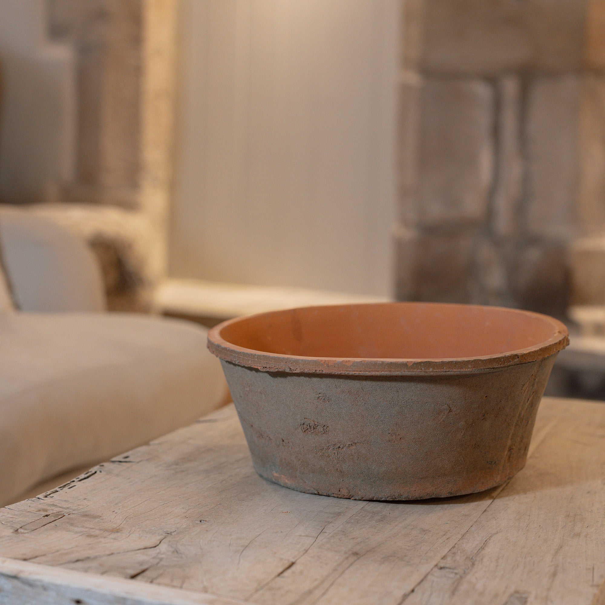 Antiqued red stone planter on coffee table.