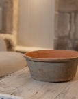 Antiqued red stone planter on coffee table.