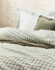 Forest green gingham bedding set on bed with throw and cushions.