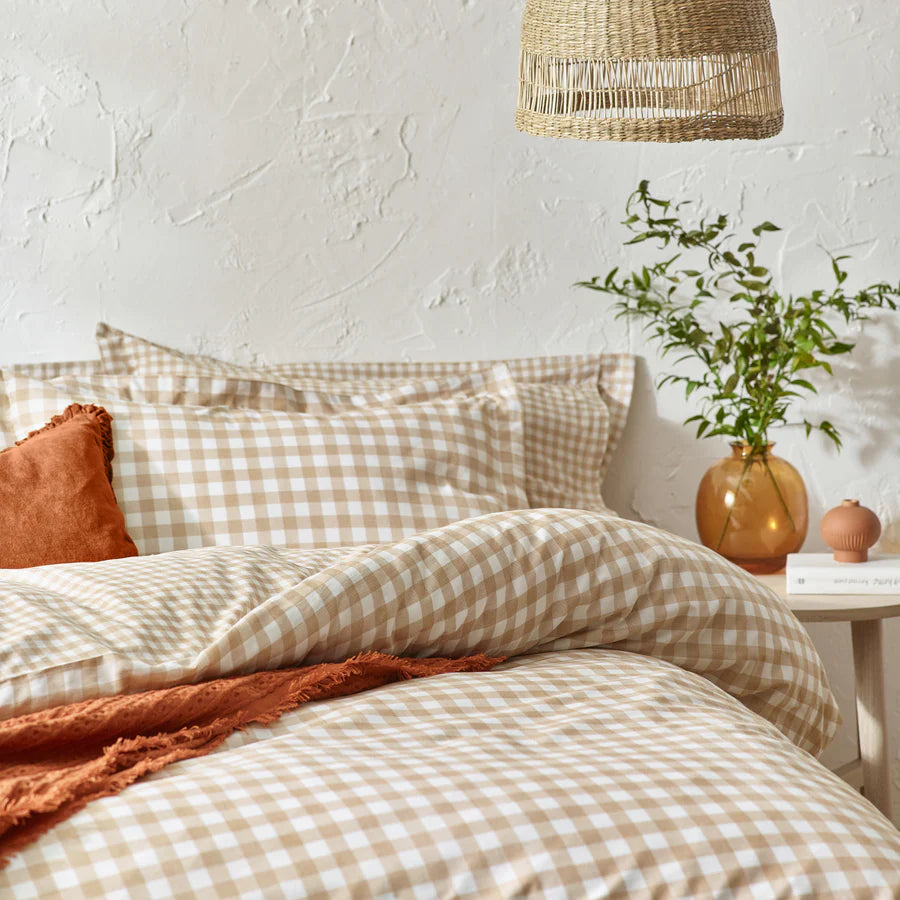 Ginger biscuit gingham bedding set on bed with cushion and throw folded.