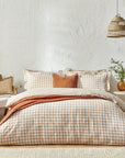 Ginger biscuit gingham bedding set on bed with cushion and throw.