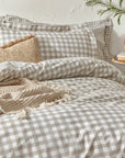 Natural gingham bedding set on bed with cushion and throw.