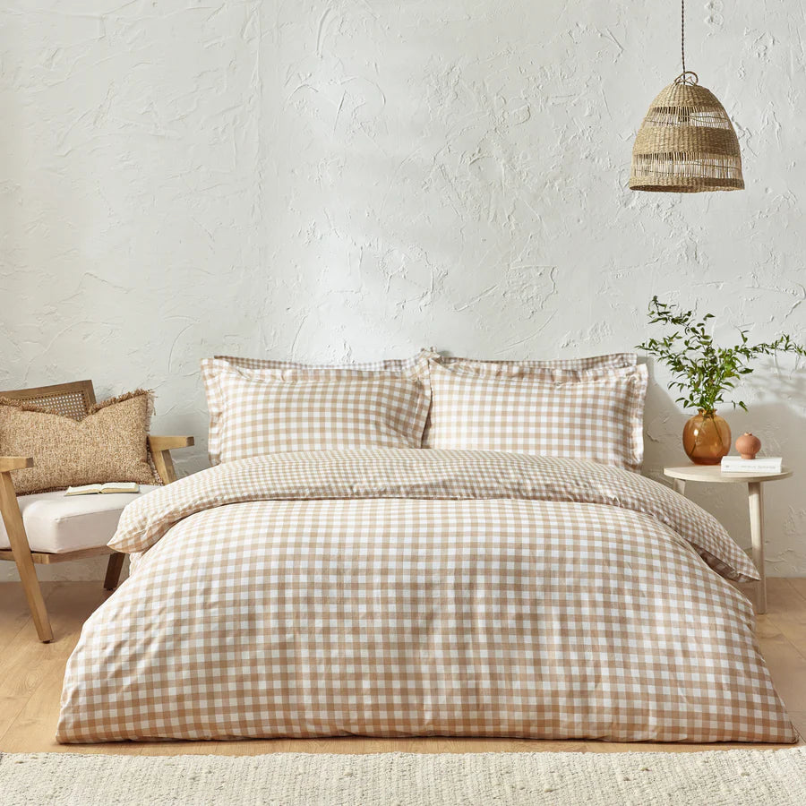 Ginger biscuit gingham bedding set on bed with bedside table and armchair.