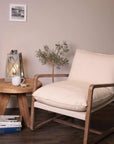 Wooden armchair styled with coffee table and plant. 