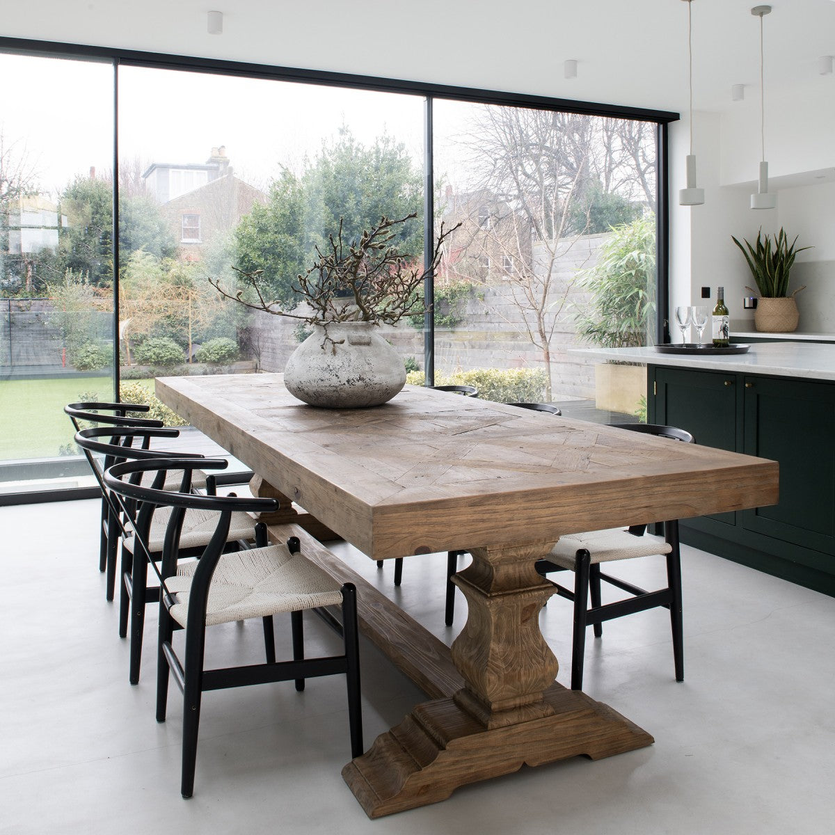 Chunky reclaimed wooden dining table in modern kitchen.