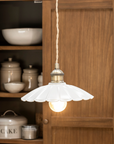 White fluted ceramic pendant light in wooden kitchen.