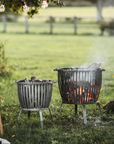 Set of two basket fire pits on lawn.