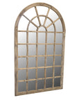 Tall arch mirror with wooden frame and panelling at an angle.