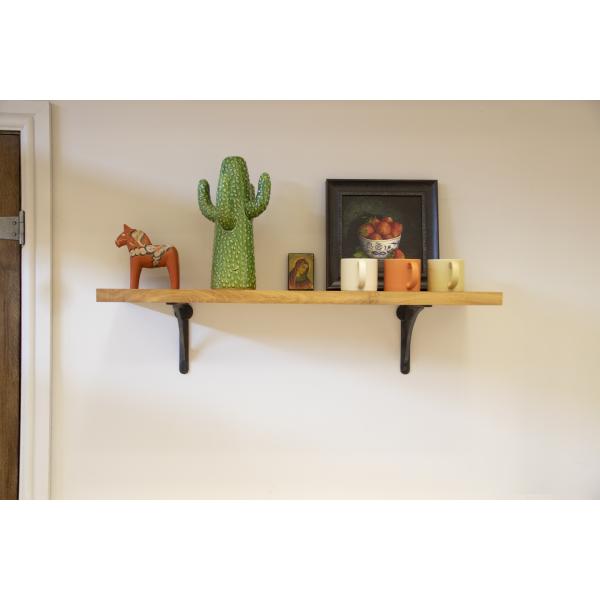 Wooden shelf with ornaments and two steel shelf brackets.