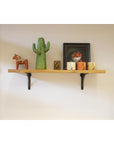 Wooden shelf with ornaments and two steel shelf brackets.