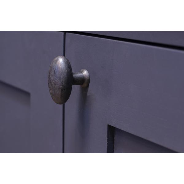 Beeswax oval cabinet knobs on navy blue cupboard.