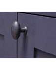 Beeswax oval cabinet knobs on navy blue cupboard.