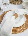 White linen napkin on white dinnerware with natural brown accessories.