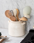 Belle Ceramic Utensil Holder on white marble countertop with wooden and metal utensils.