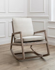 Mango wood rocking chair with natural plush cushions in the corner of an empty room.