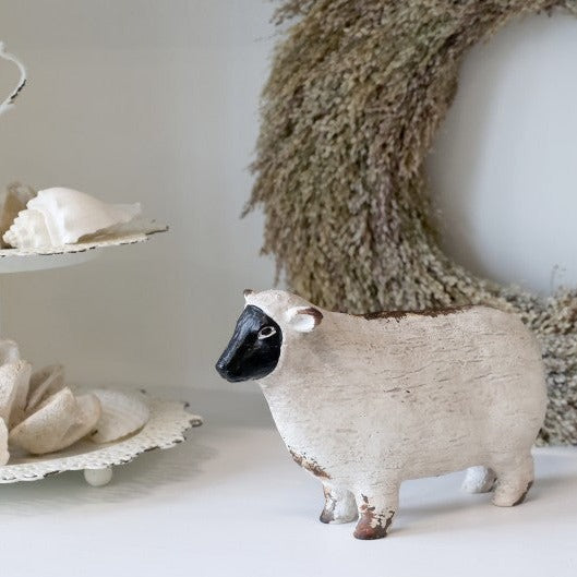 Painted sheep ornament with cake stand and wreath.