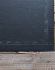 Close up of black top on reclaimed wood writing desk.