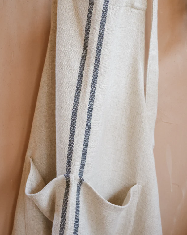 Close up of cream and blue striped linen apron.