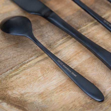 Close up of stainless steel marking on black cutlery set.