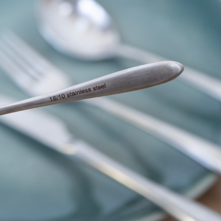 Close up of stainless steel stamp on silver cutlery set.