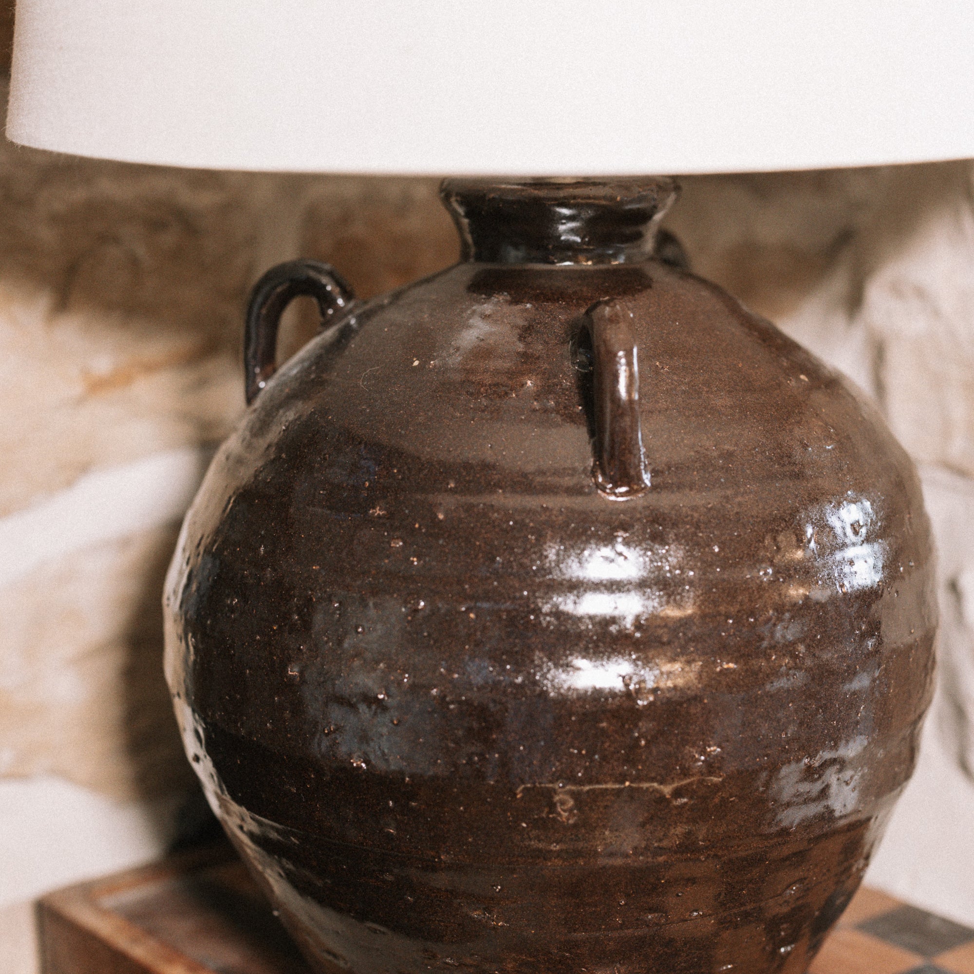 Detailed shot of the Large brown Table Lamp With Linen Shade on wooden chess board against stone wall. 