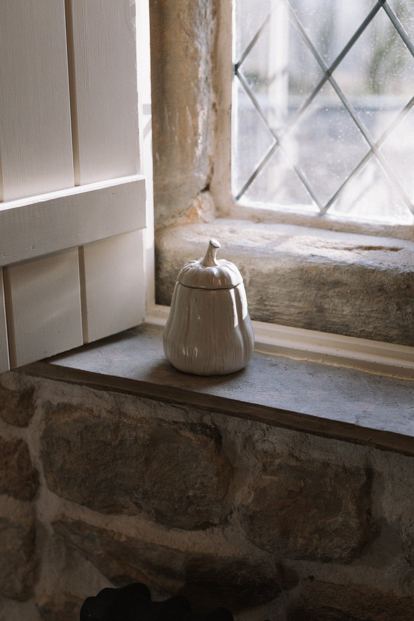 Butternut squash Jar with Lid on stone windowsill with wooden shutter.