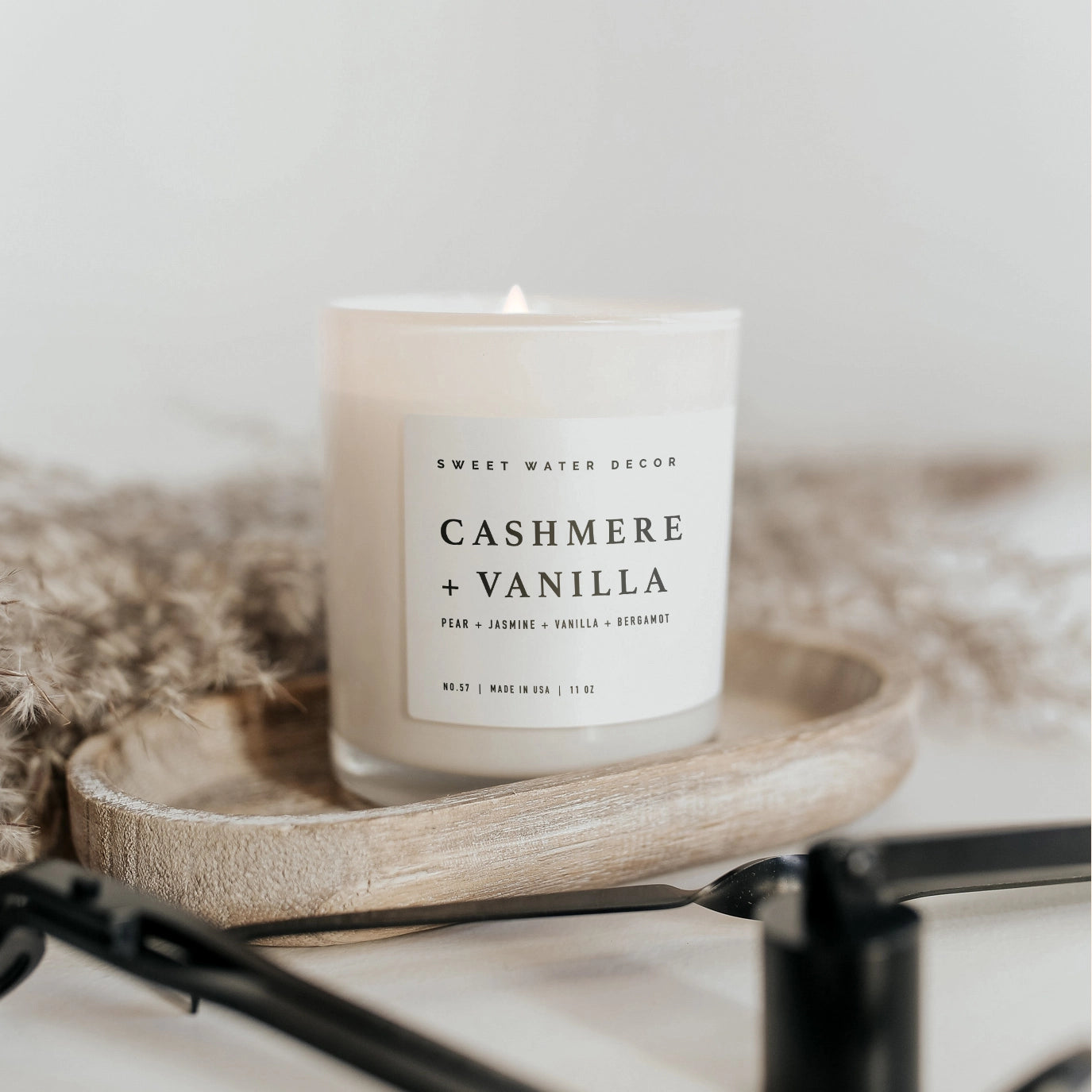 Cashmere and vanilla soy candle in white jar on wooden tray. 