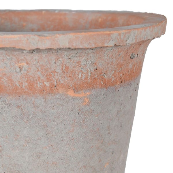 Close up of red antiqued stone plant pot.