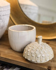 Ceramic acorn storage jar with lid off.