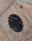 Close up of black buckle on wooden trunk.