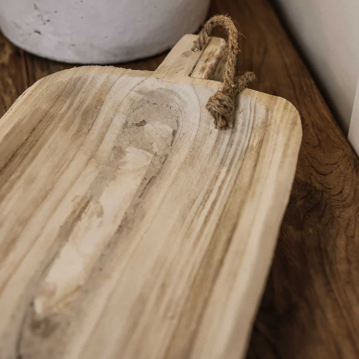 Close up of wooden tray handle with rope.
