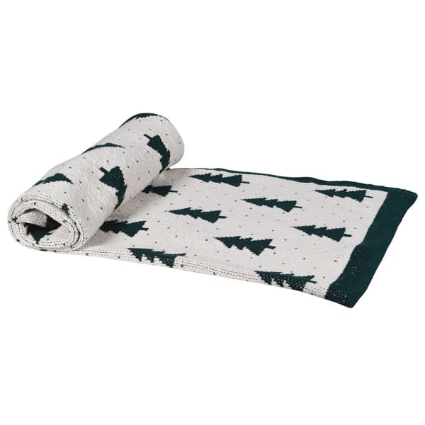 White cotton throw with Christmas tree and polkadot pattern with green border, rolled up and folded.