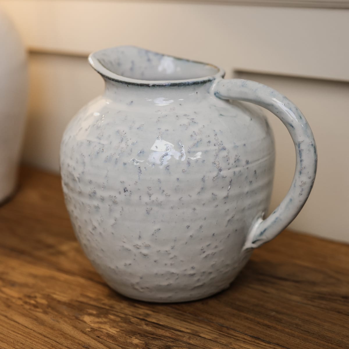 Small ceramic jug with blue speckled glaze.