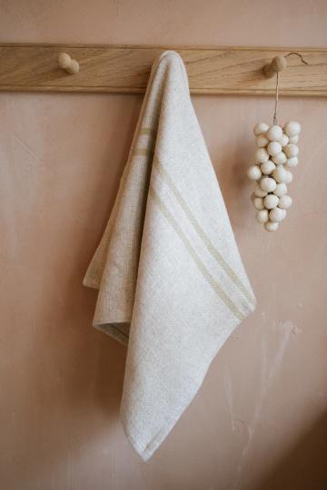 Cream striped kitchen towel hanging from a wooden hook.