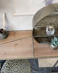 Birds eye view of wooden desk with brass detail with other brass decor items.