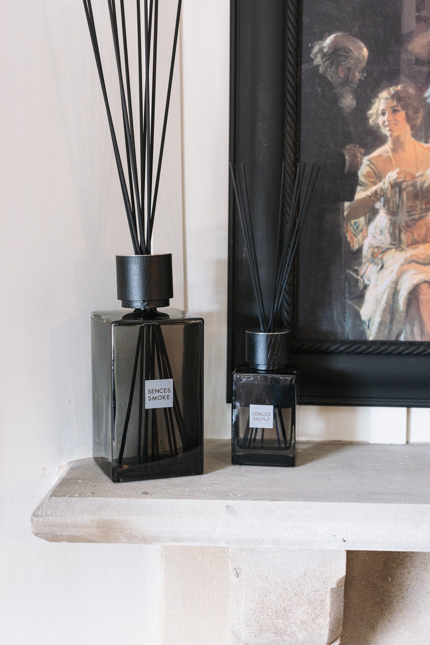 Extra large smoke sences reed diffuser with small smoke sences reed diffuser on stone mantle with black painting.