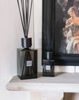 Extra large smoke sences reed diffuser with small smoke sences reed diffuser on stone mantle with black painting.