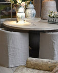 Natural linen dining chair under round farmhouse table.