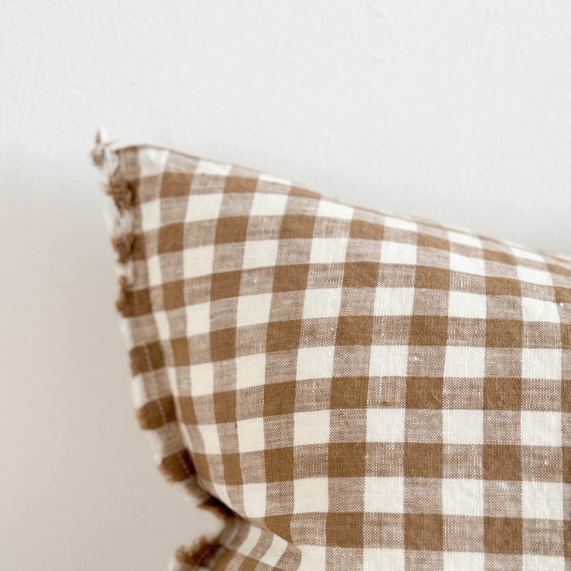 Close up of pattern on brown and cream gingham linen cushion.