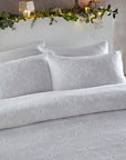 Close up of white Christmas bedding with snowflakes on double bed.