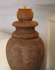 Close up of wooden lamp shade base with brass top.