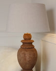 Wooden lamp close up with beige lamp shade on white background.