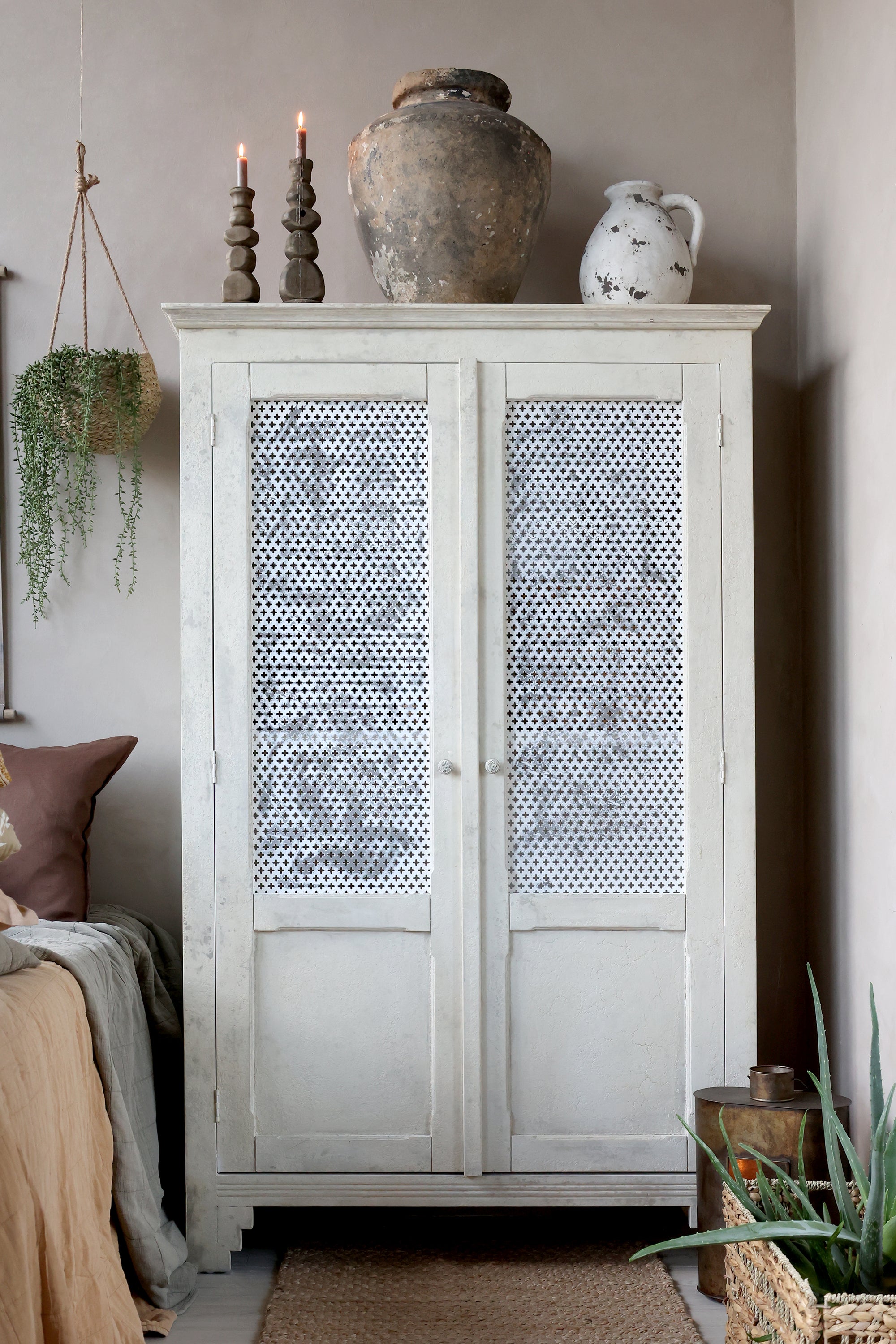 Antique cream linen closet with mesh doors.