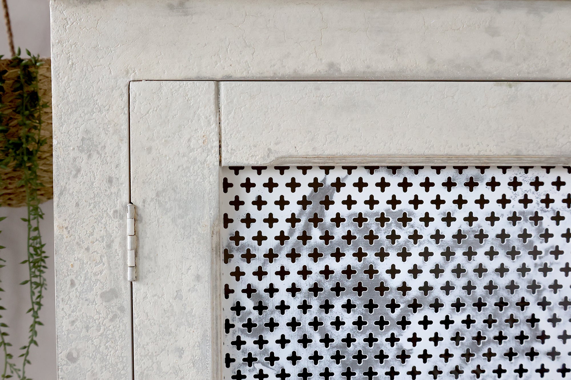 Close up of mesh panel door on antique cream linen closet.