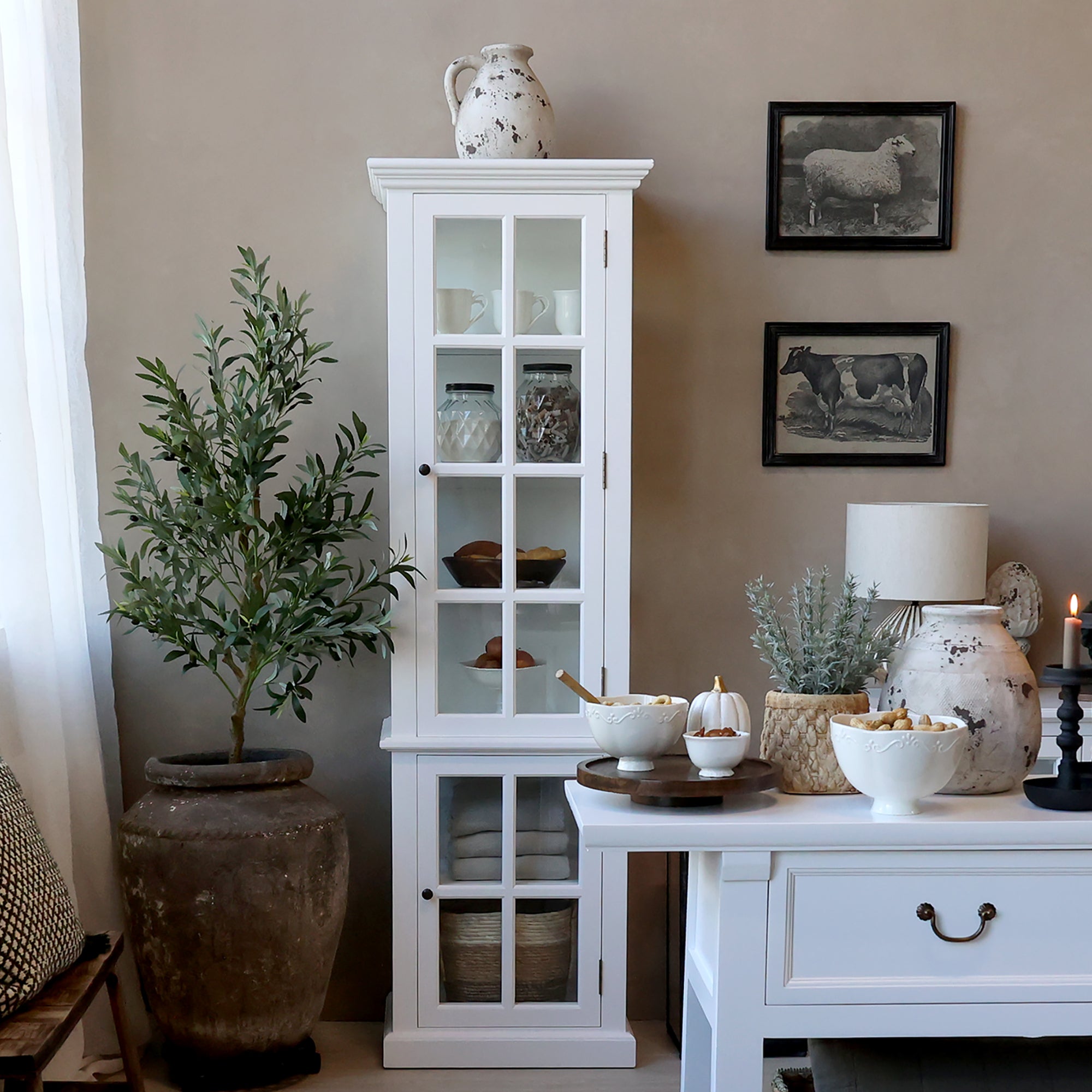 White display cabinet with glass doors open and kitchen accessories on the shelves.