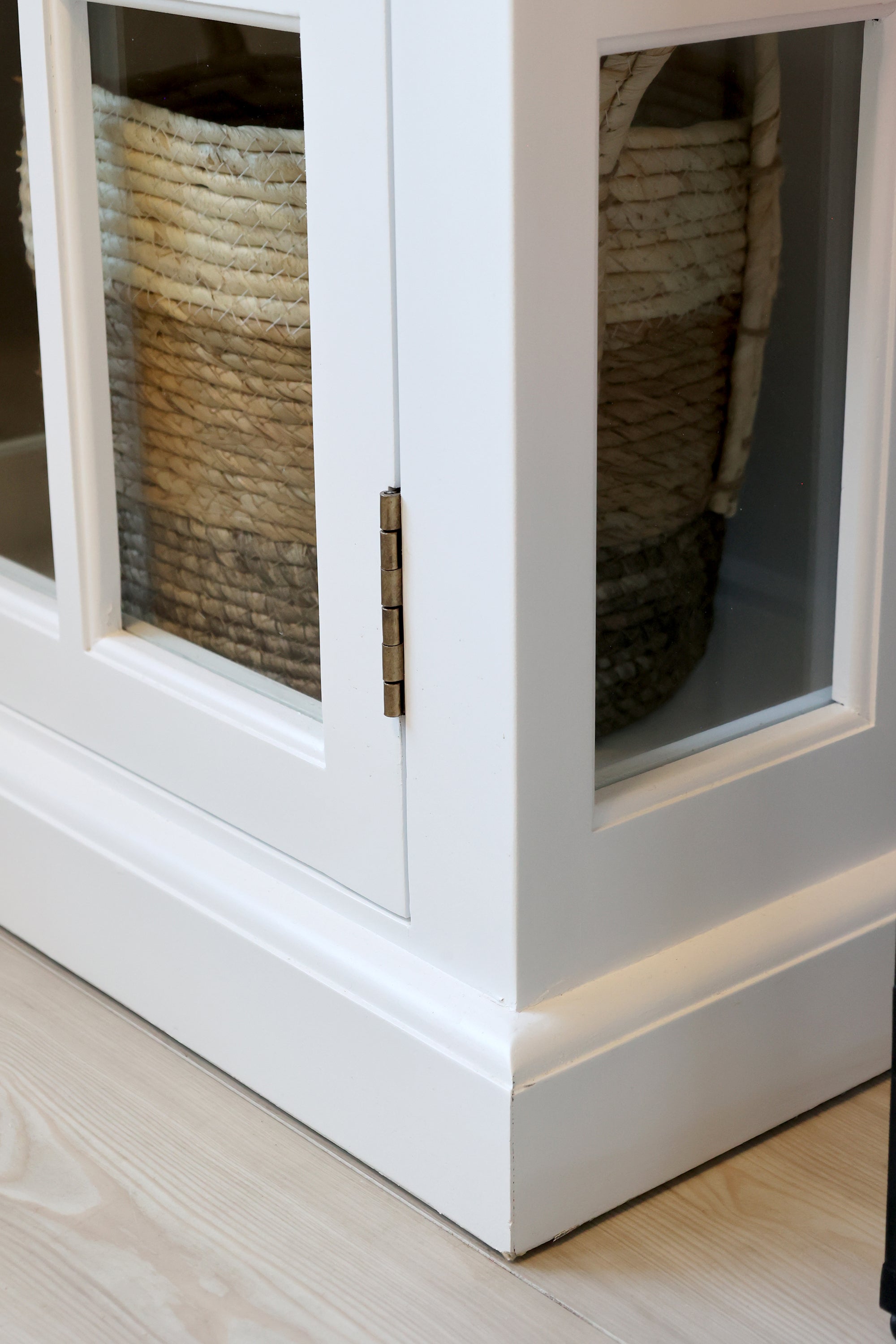 Close up of corner and hinges on white display cabinet.